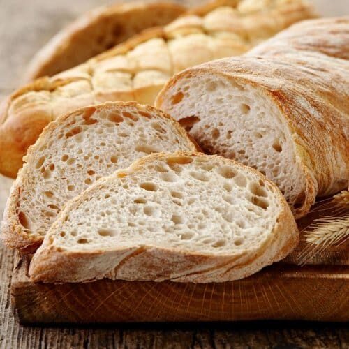 Freshly sliced rustic bread on a wooden board.